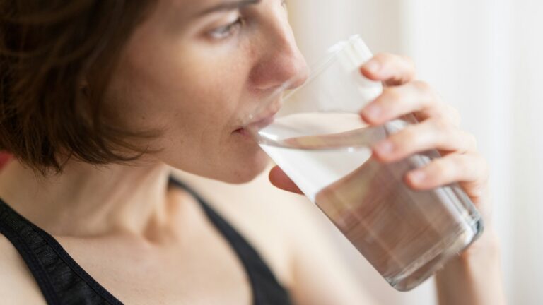 Woman drinking water to manage GLP-1 side effects